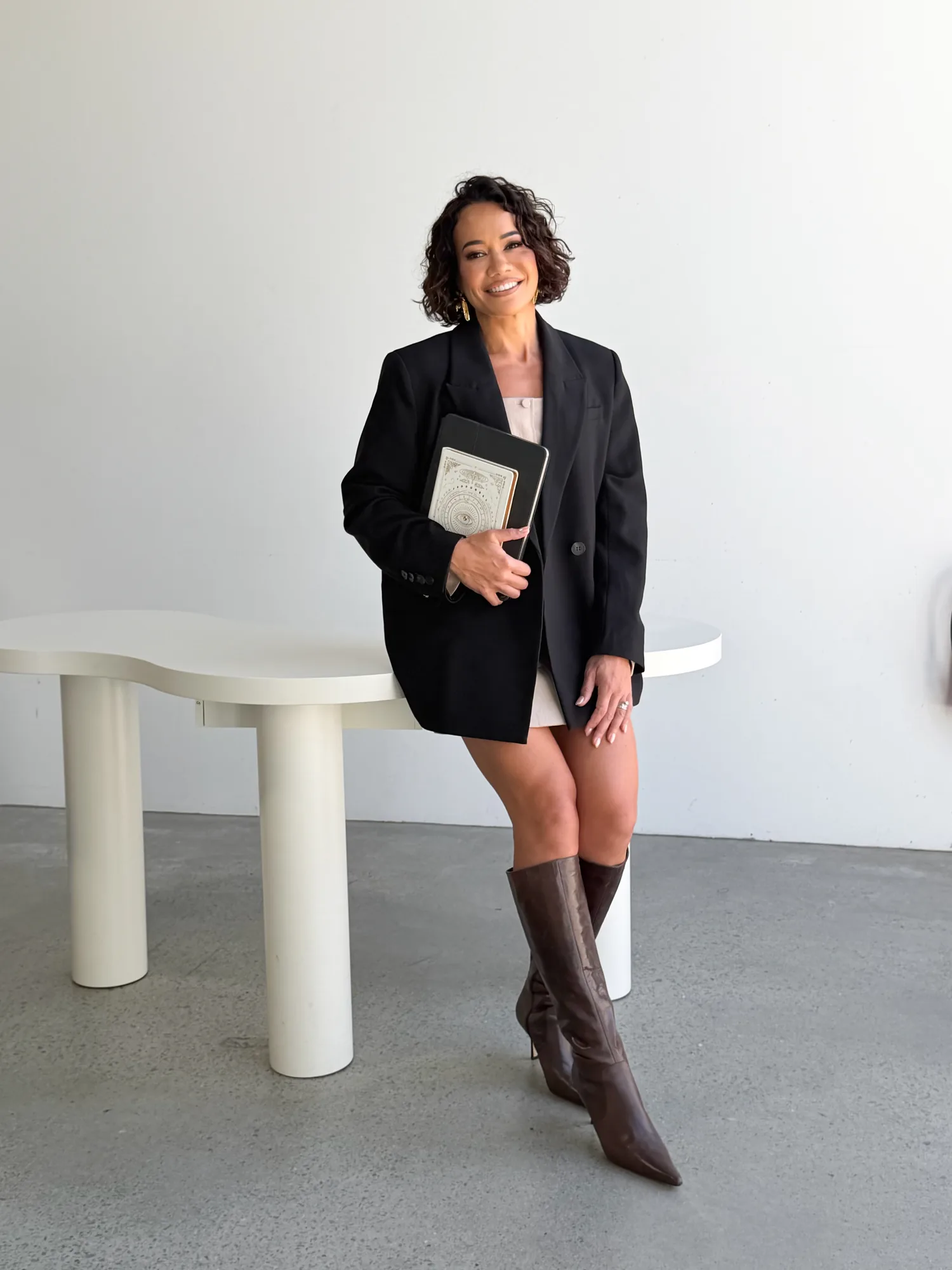 Delyse Armstrong, full-length editorial portrait, holding a journal