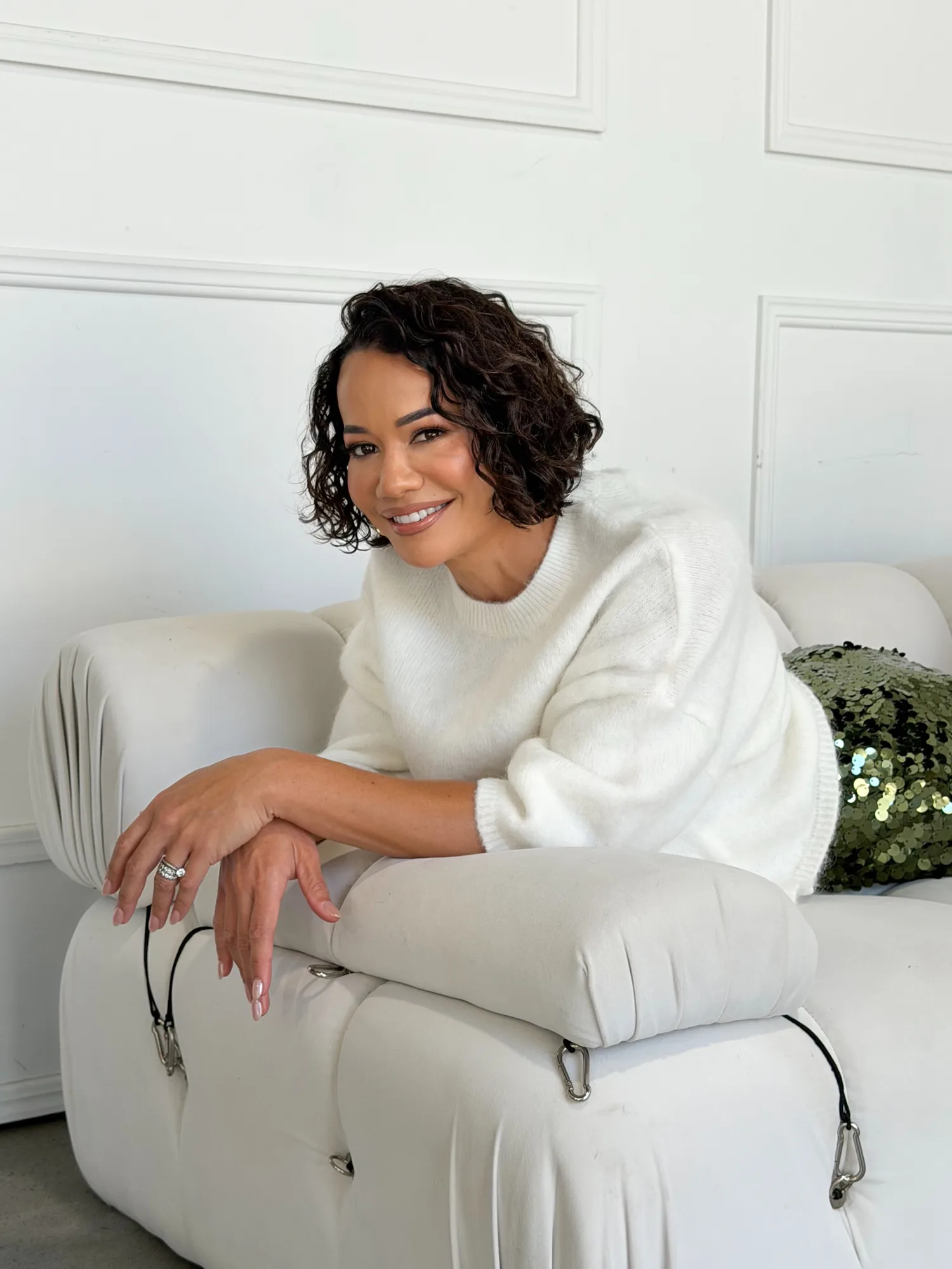 Delyse resting softly on a cream sofa